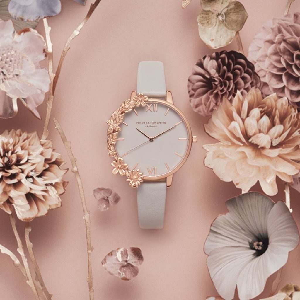 Montre rose entourée de fleur